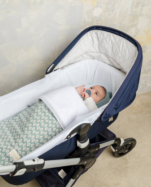 Bebe-con-saquito-y-cubre-capazo-Gabis